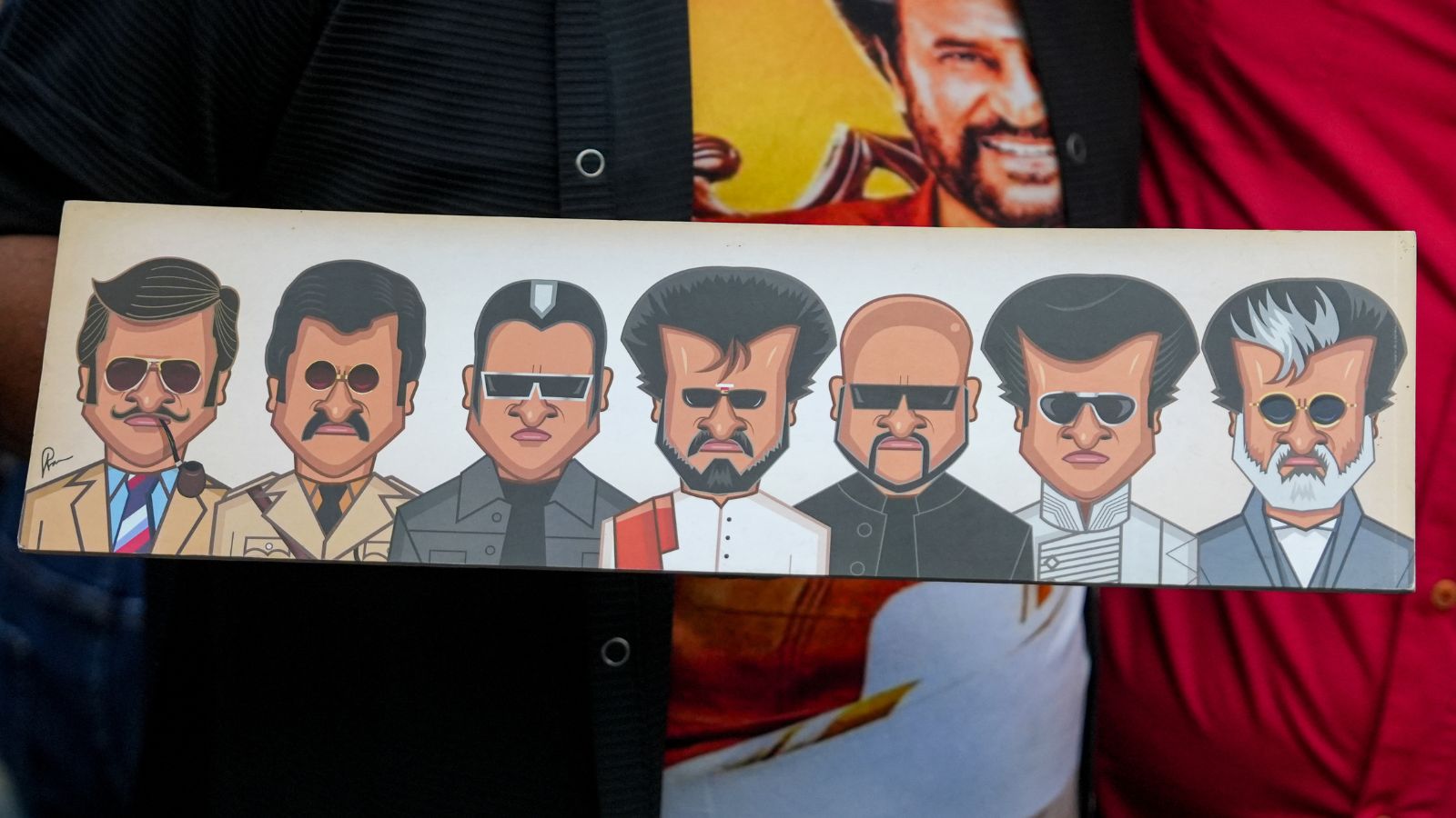 A fan shows a placard featuring actor Rajinikanth's movie characters during the release of his film Jailer 2. Photo: PTI