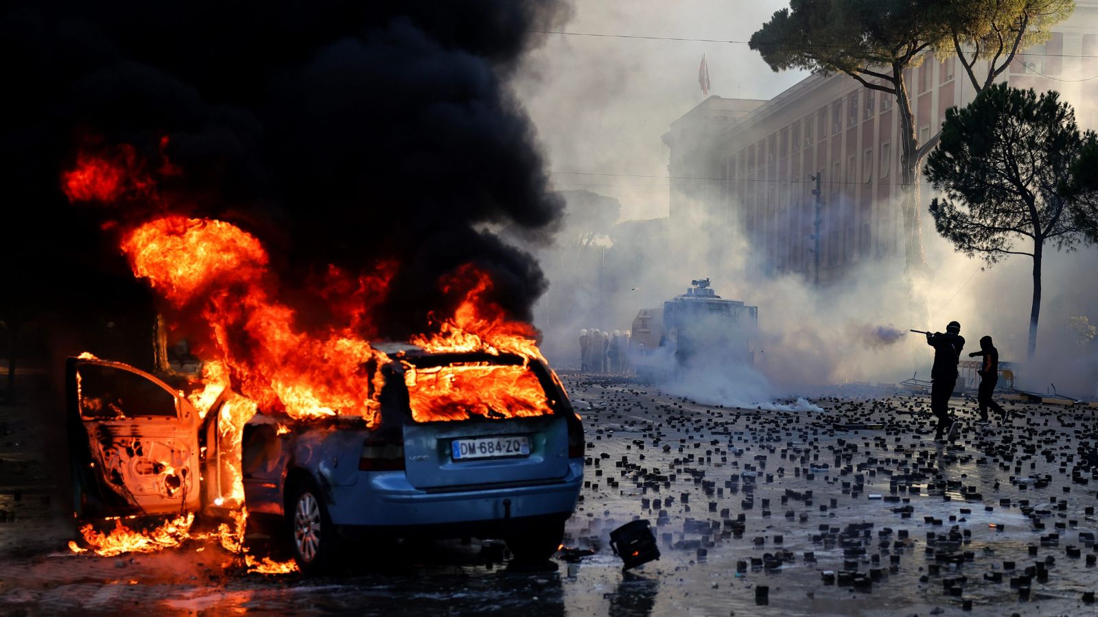 Burning car and streets filled with stones in Albania. Photo: AP via PTI