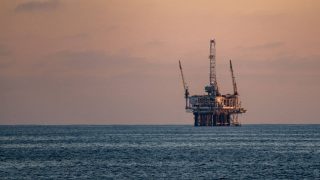 Wall Street drifts below its all-time high as oil prices keep swinging